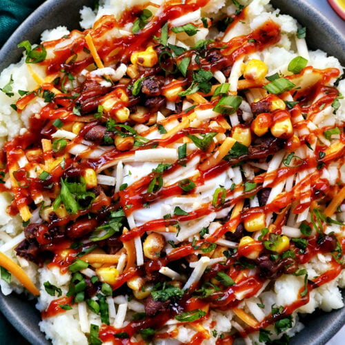 loaded potato bowl with mashed potatoes, beans, corn, cheese, and herbs.