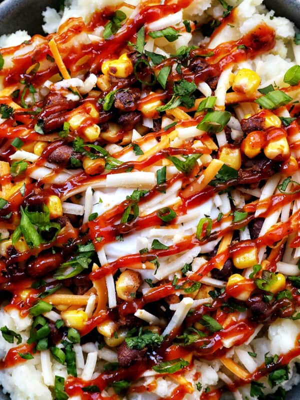 loaded potato bowl with mashed potatoes, beans, corn, cheese, and herbs.