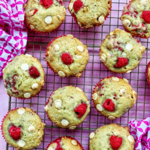 raspberry white chocolate chip muffins on a wire rack.