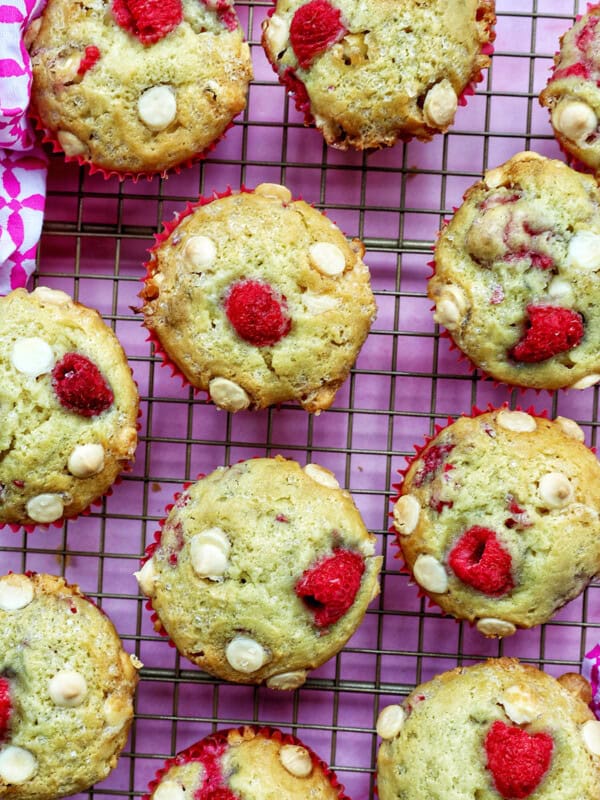raspberry white chocolate chip muffins on a wire rack.