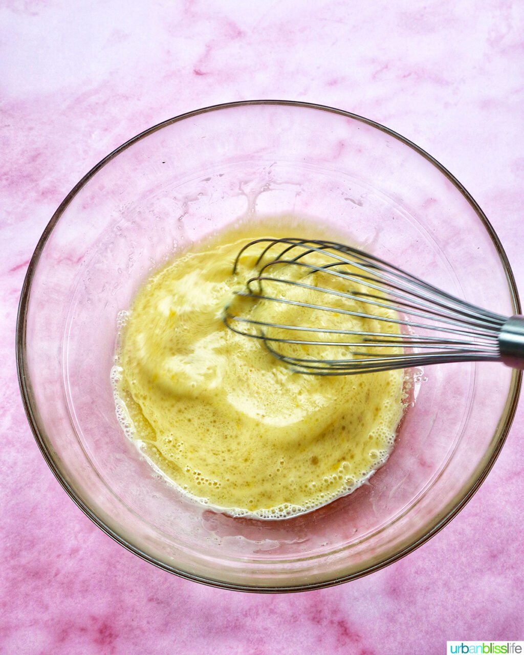 whisk whisking batter for muffins in a bowl.