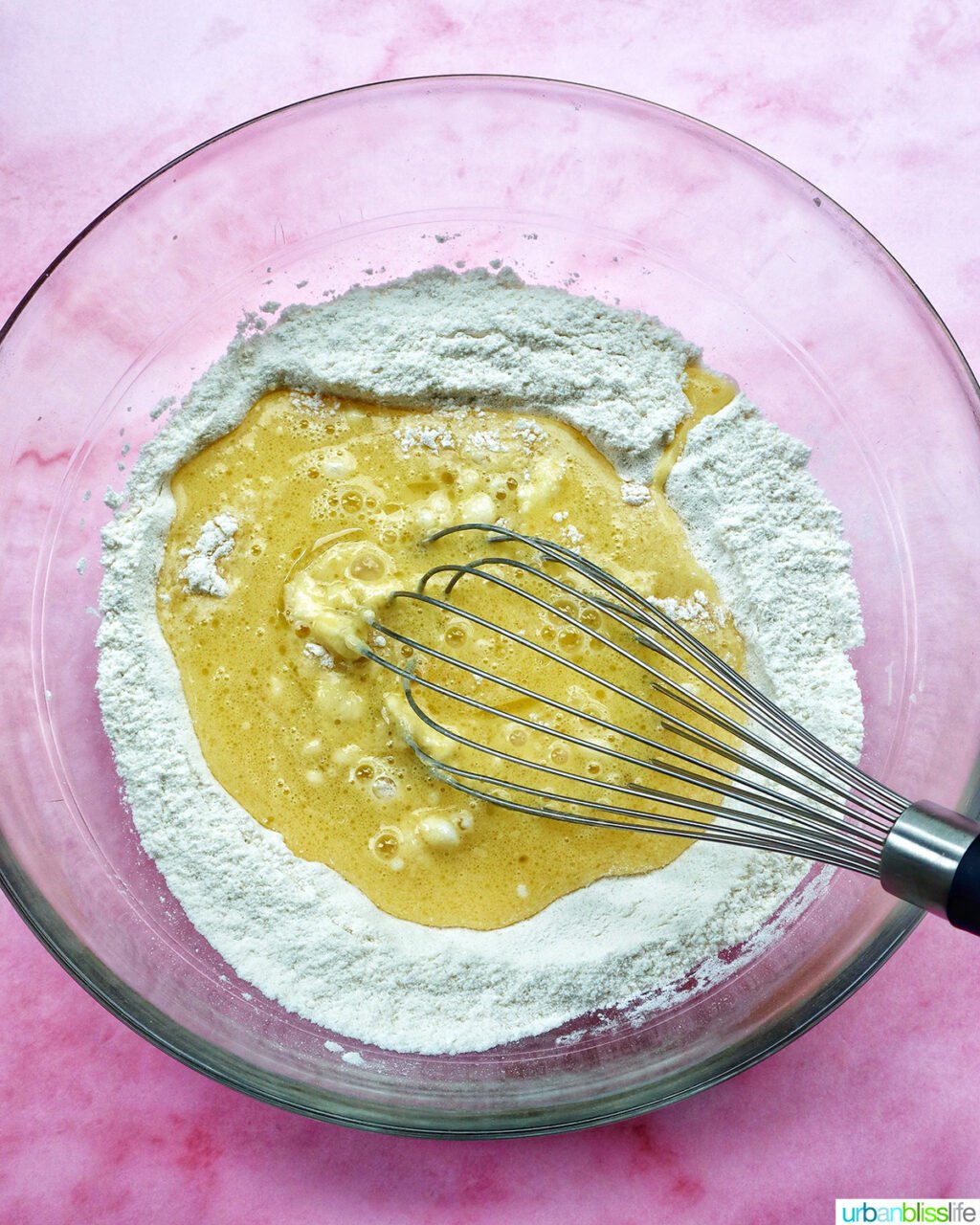 whisk whisking batter for muffins in a bowl.