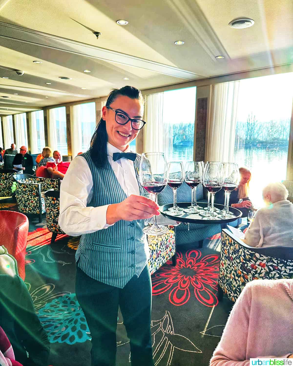 waitress with tray of wine glasses onboard the AmaKristina with AmaWaterways.