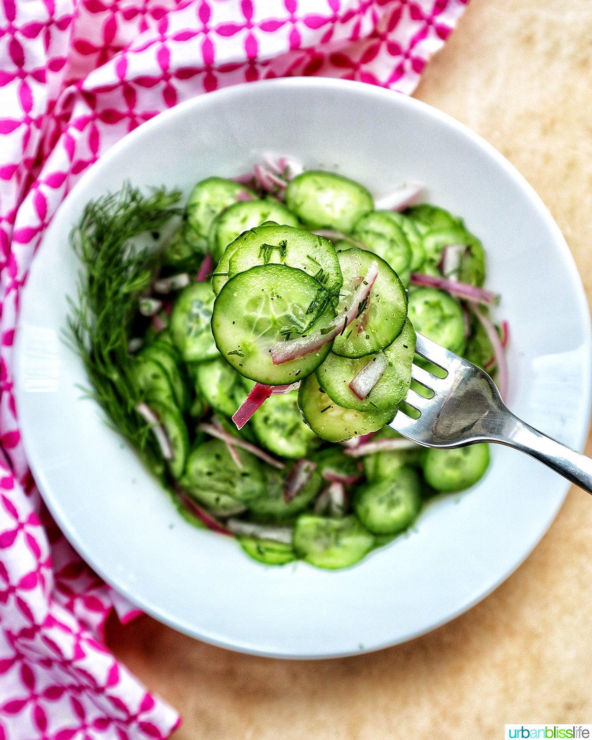 bowl of cucumber dill salad with forkful of salad.