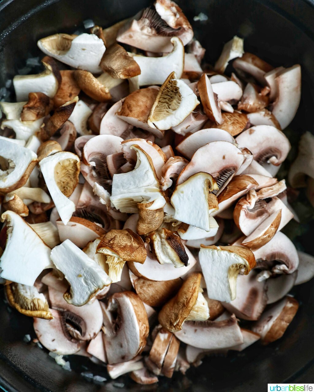 sliced onions added to a pot.