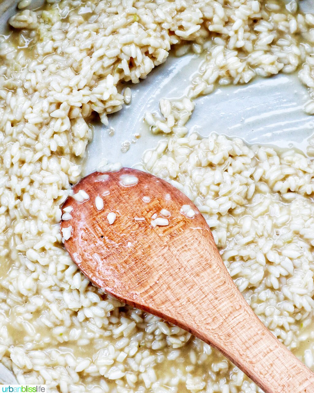 wooden spoon stirring risotto cooking.