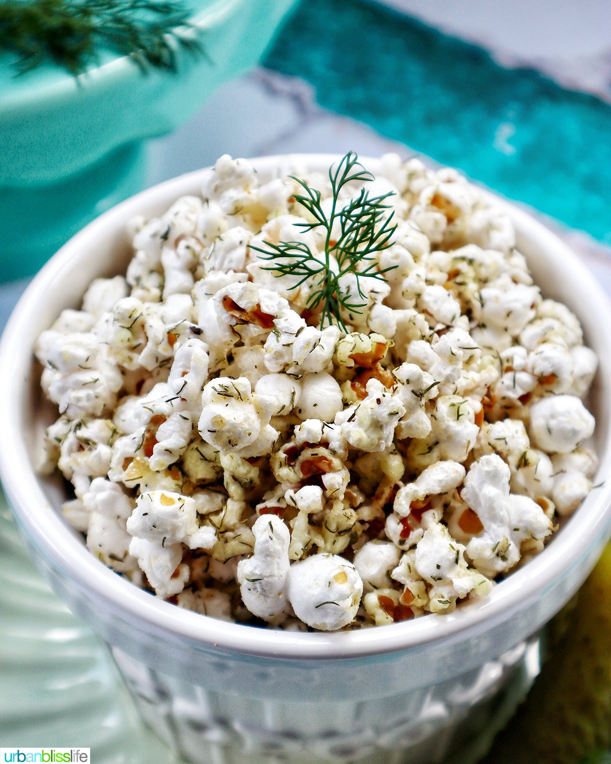 dill pickle popcorn in a white bowl.