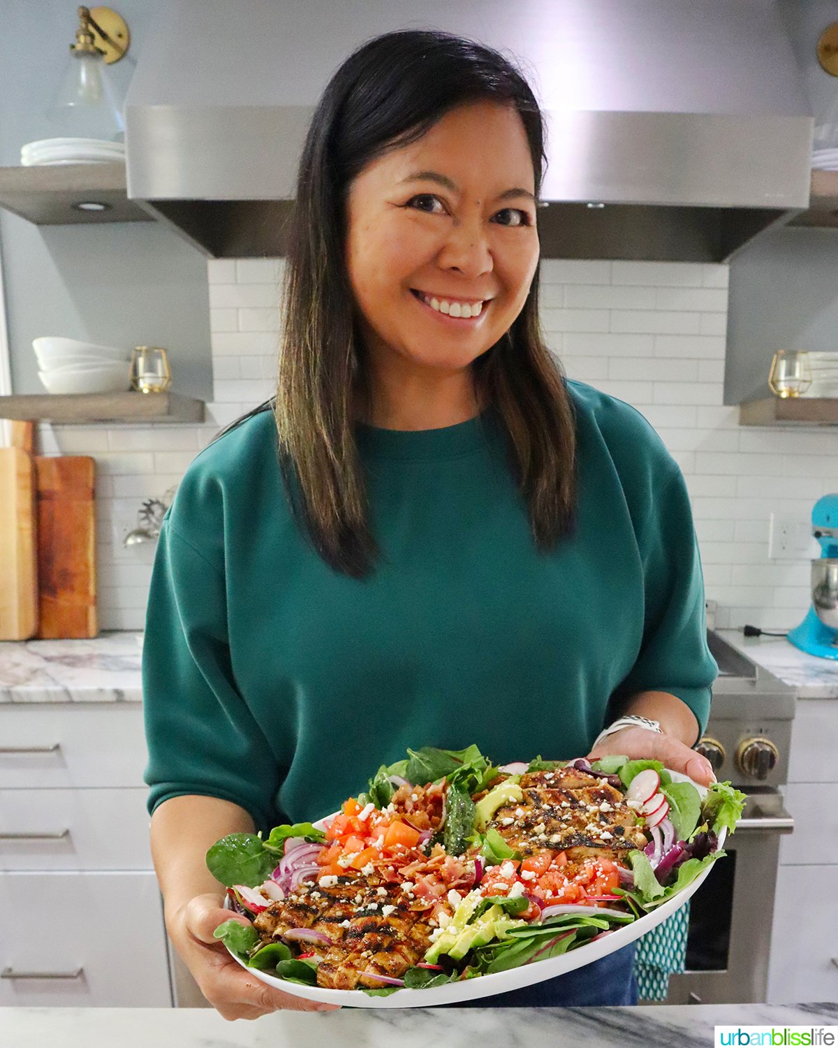 Marlynn Jayme Schotland holding a platter of Balsamic Chicken Salad.