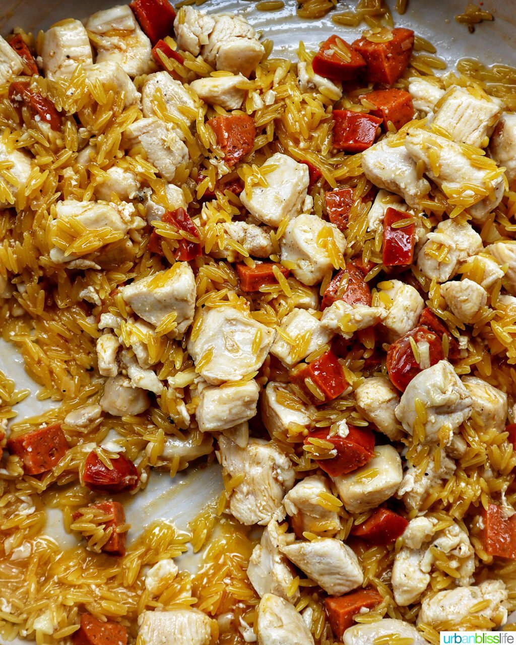 chorizo and chicken cooking in a pan.