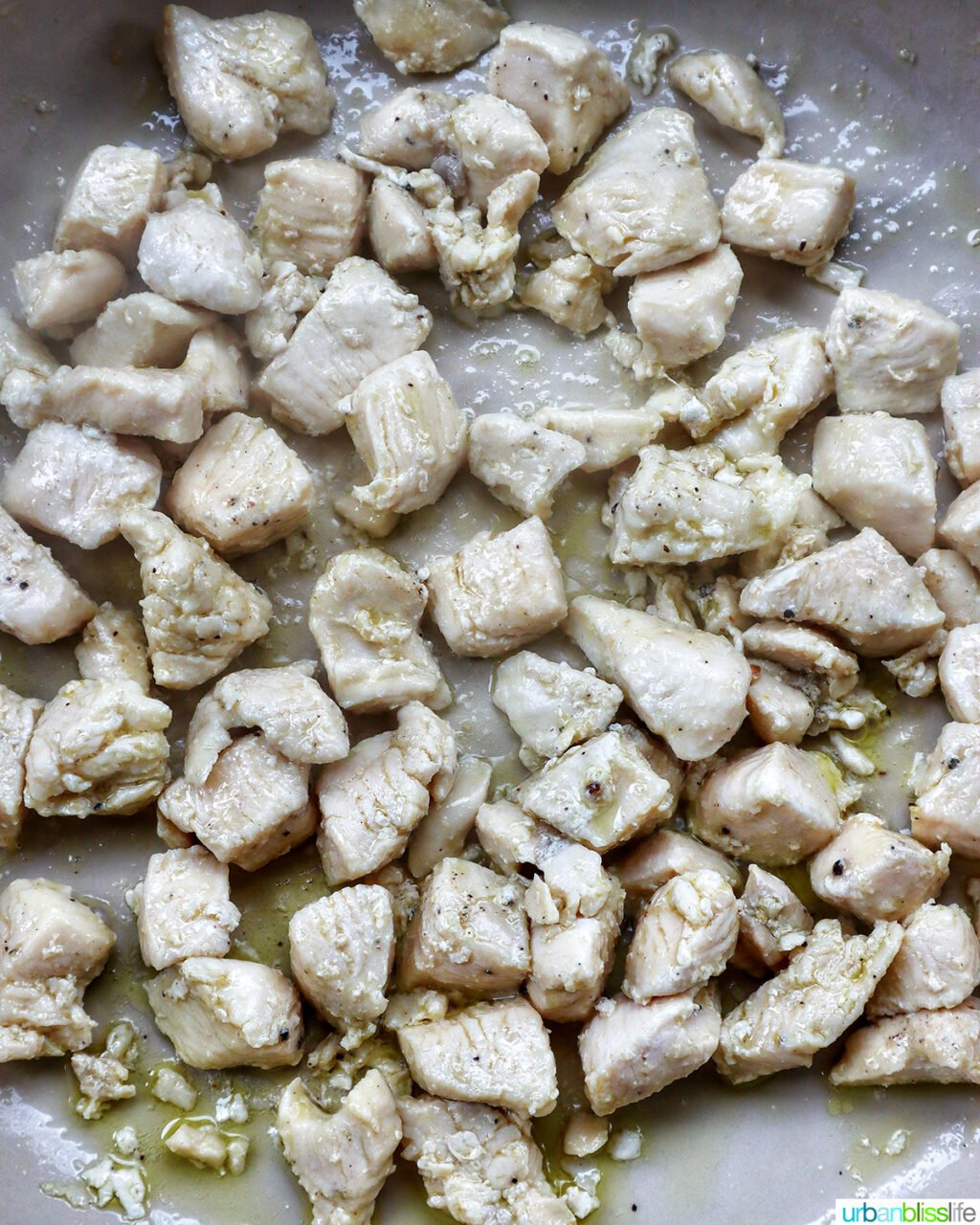 cubed chicken cooking in a pan.