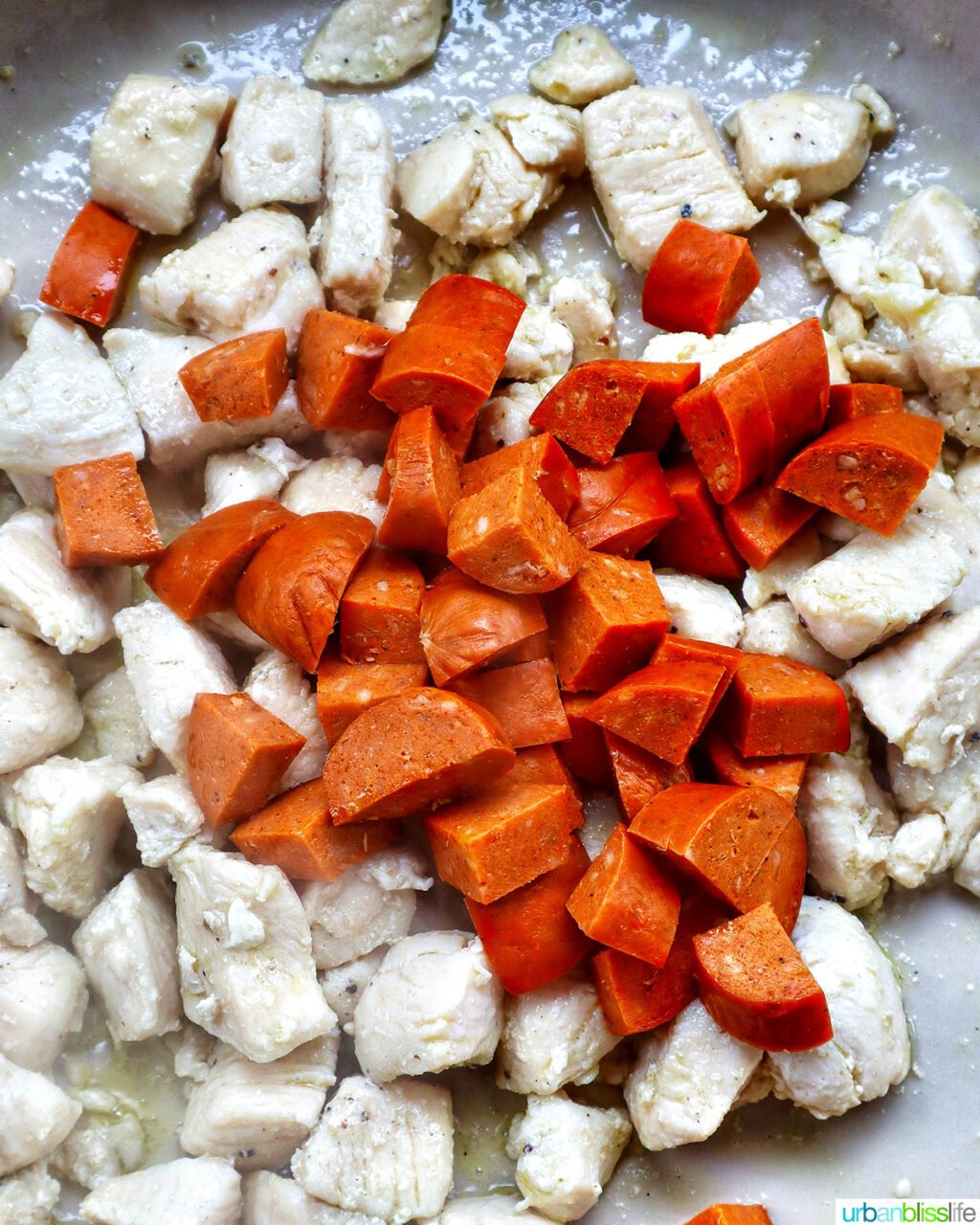 chorizo and chicken added to a pan.