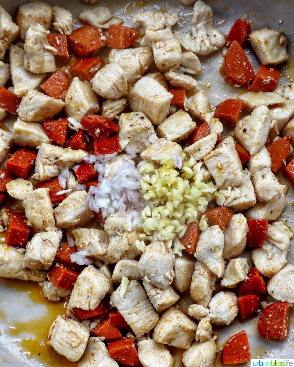 garlic, onions, chorizo, chicken in a pan.