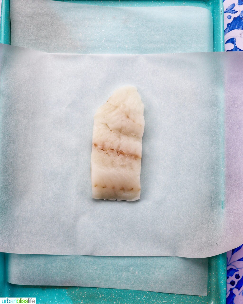 cod white fish on parchment paper on a baking sheet.