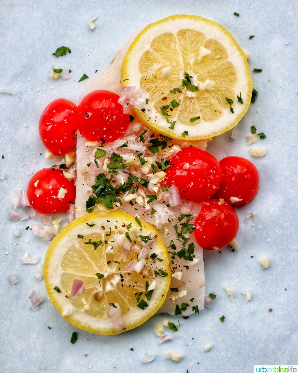 cod white fish covered in parsley, tomatoes, shallots, garlic, and lemons.