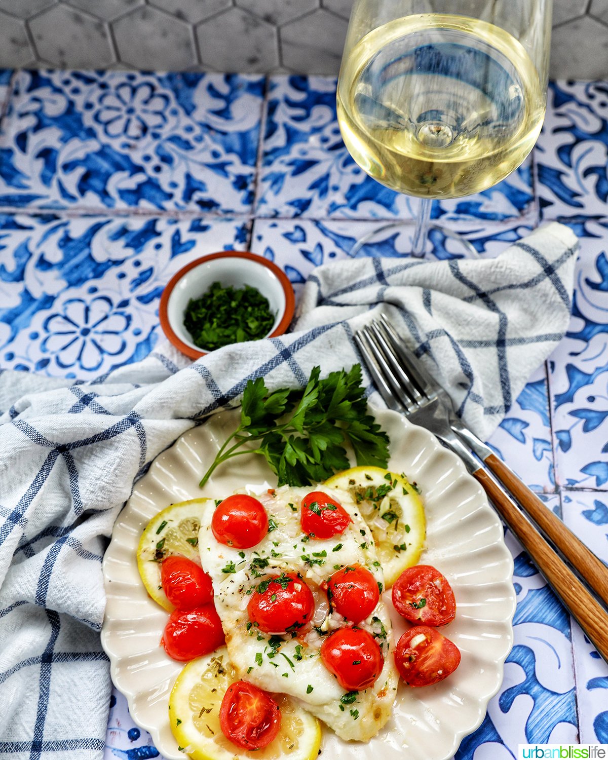 Cod en Papillote with white wine glass and two forks.