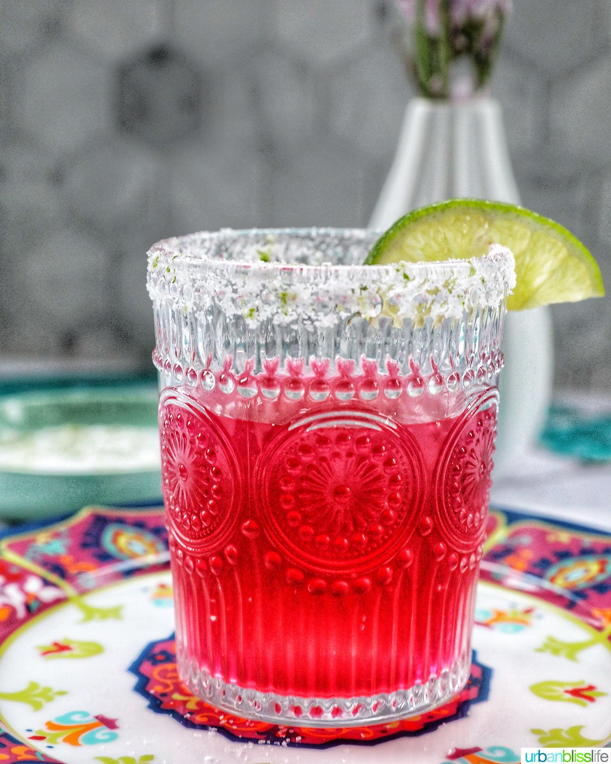 glass of prickly pear margarita with lime slice garnish.