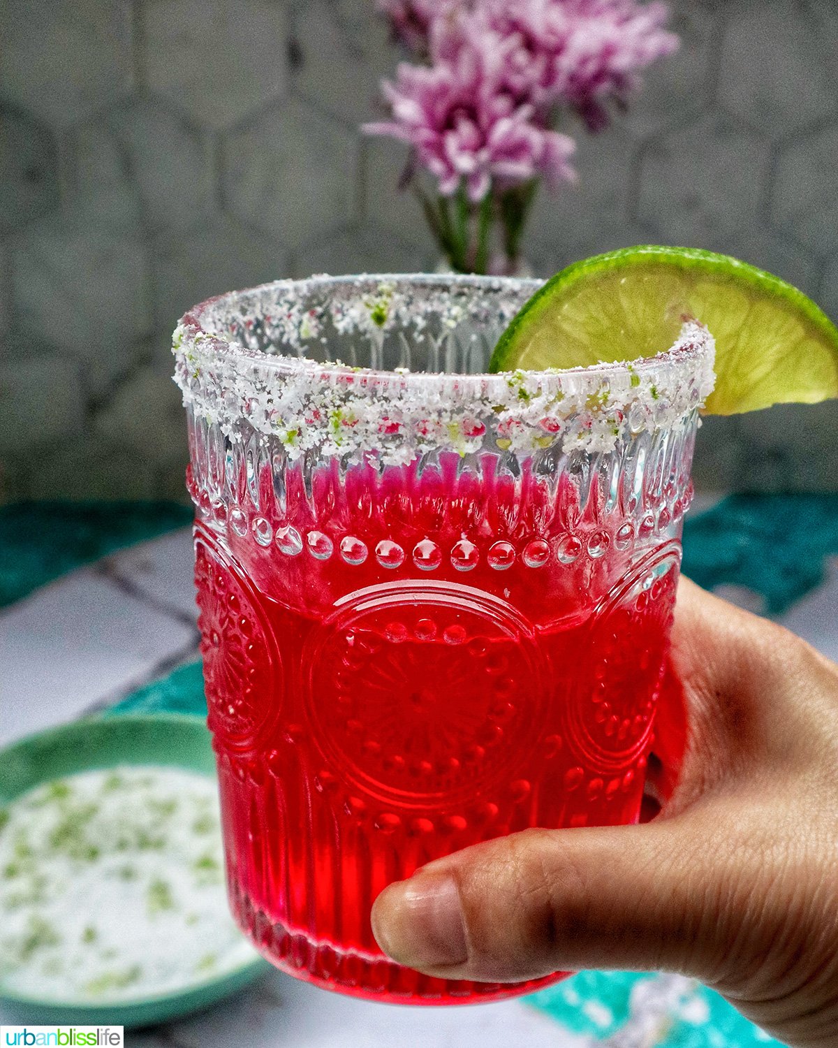 glass of prickly pear margarita with lime slice garnish.