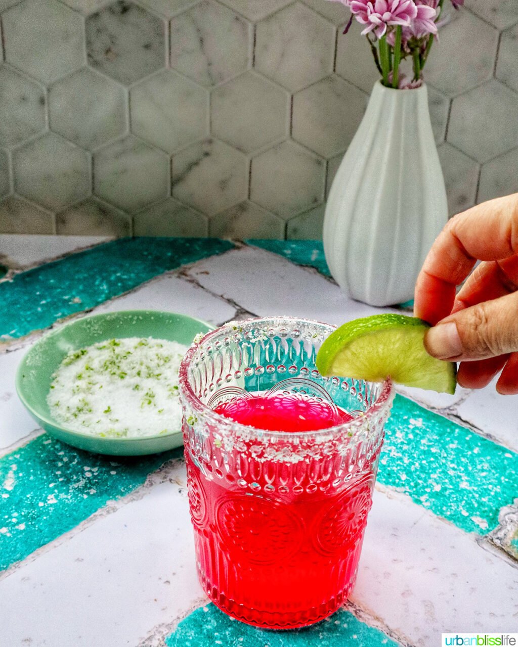 glass of prickly pear margarita with lime slice garnish.