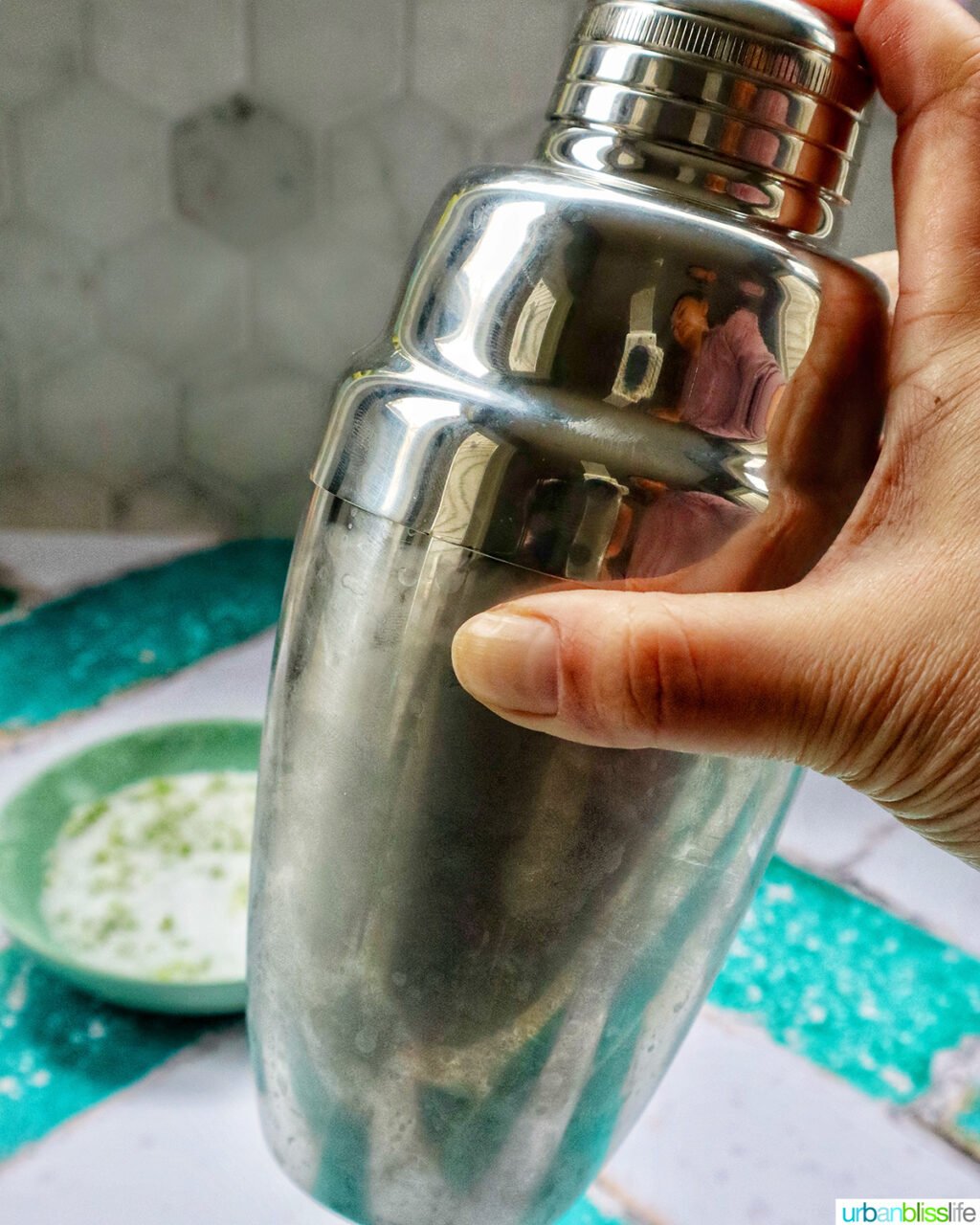 hand shaking a cocktail shaker.