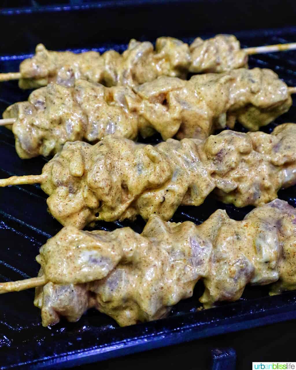 bang bang chicken skewers cooking on a grill pan.