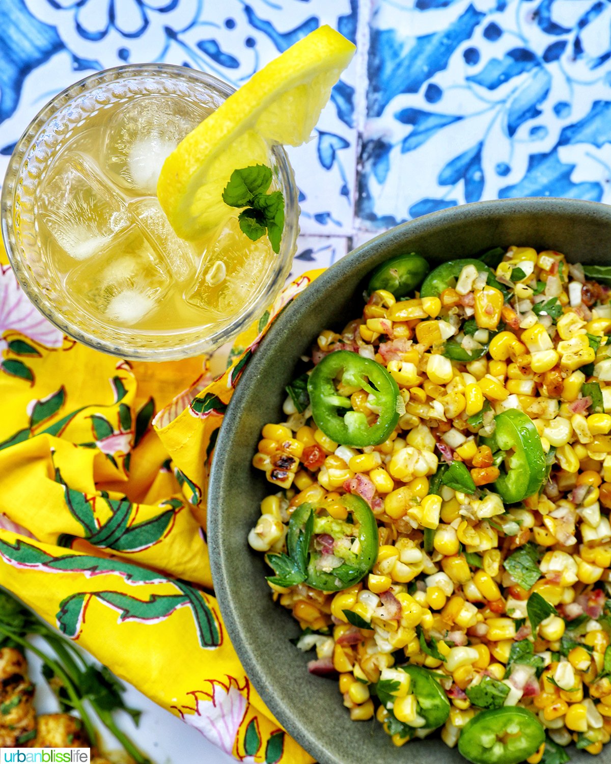 bowl of charred corn salad with glass of bourbon lemonade.