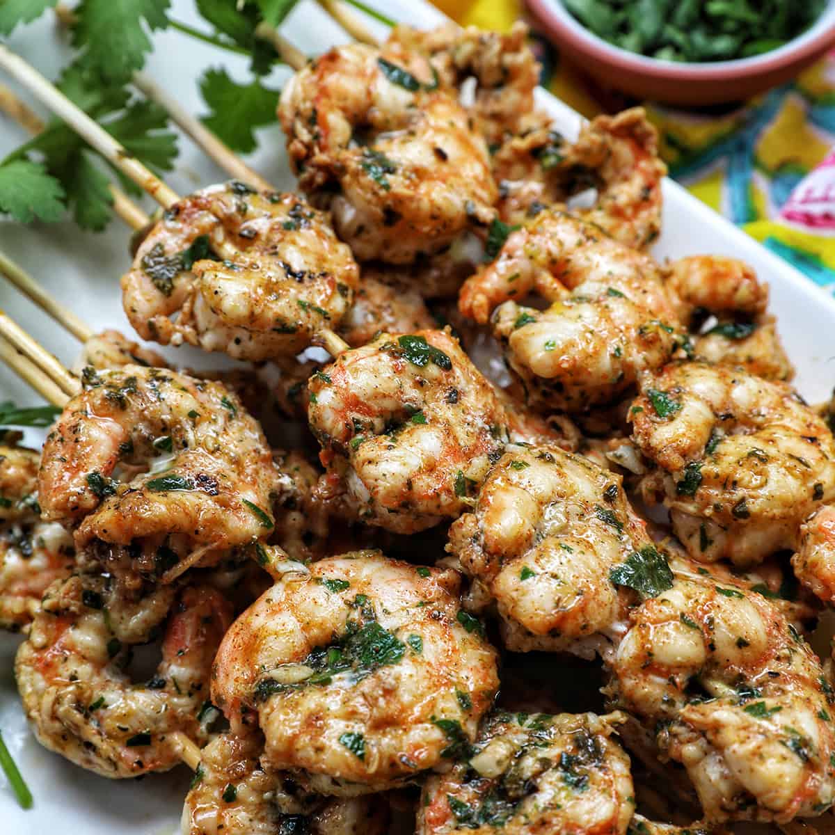 prawn BBQ skewers stacked on a plate.