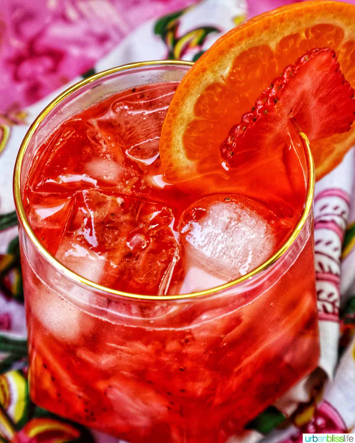 strawberry spritz with orange and strawberry garnish.