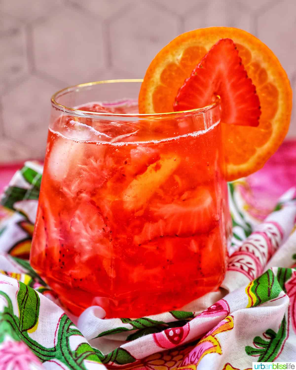 strawberry spritz with orange and strawberry garnish.