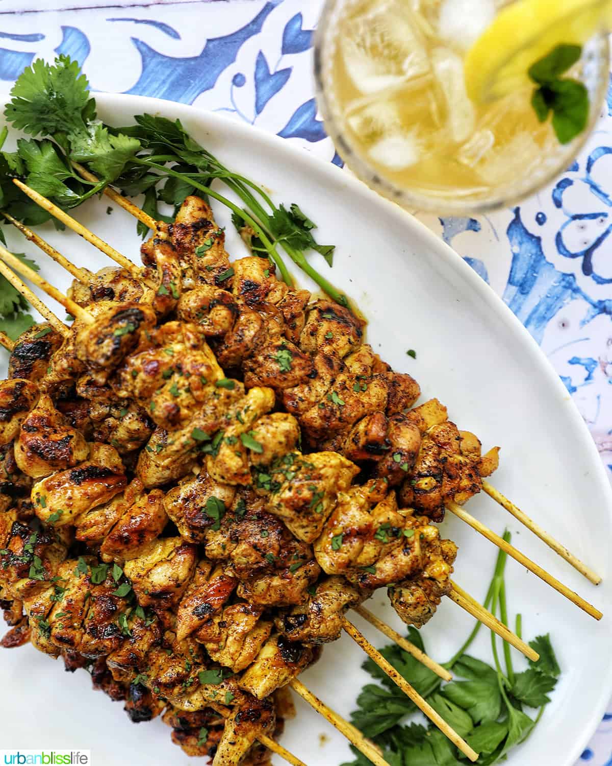 tandoori chicken skewers with glass of bourbon lemonade.
