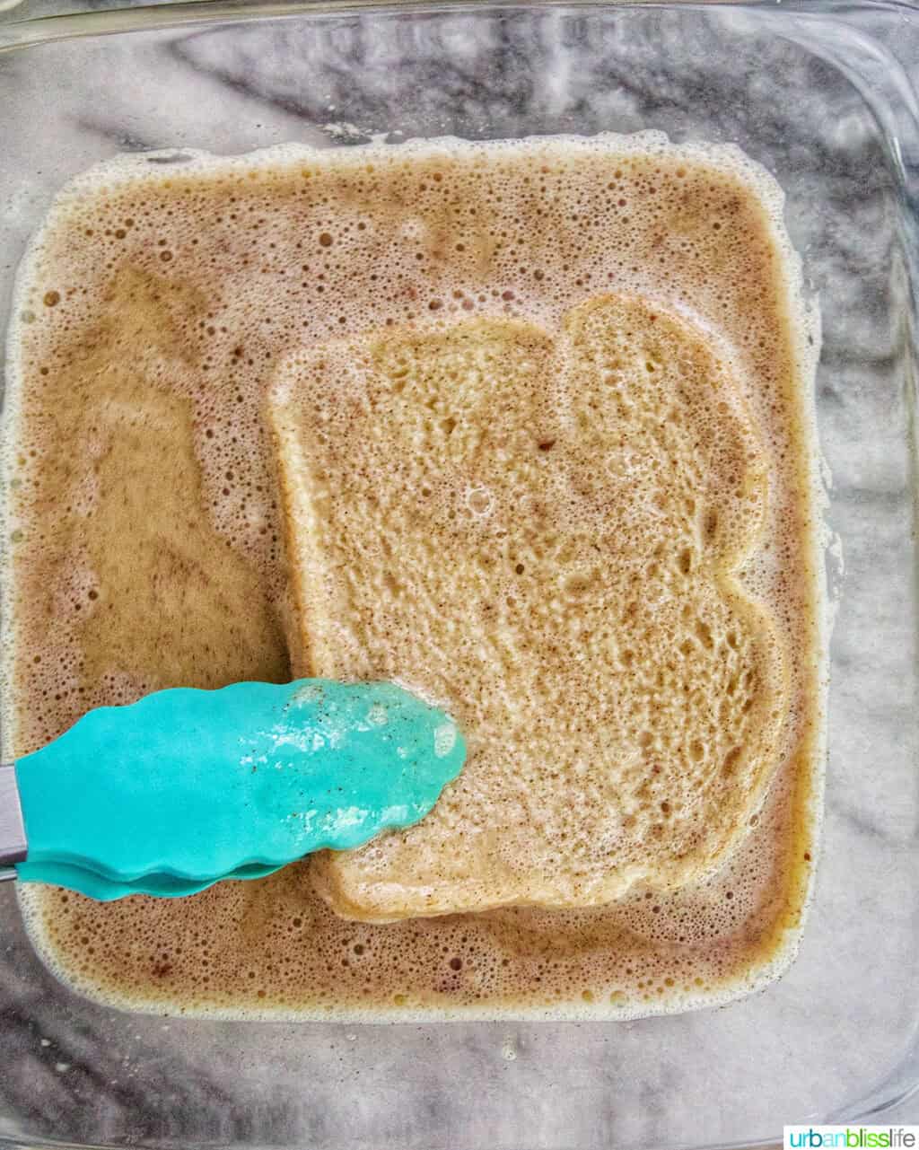 tongs dipping high protein french toast into batter.