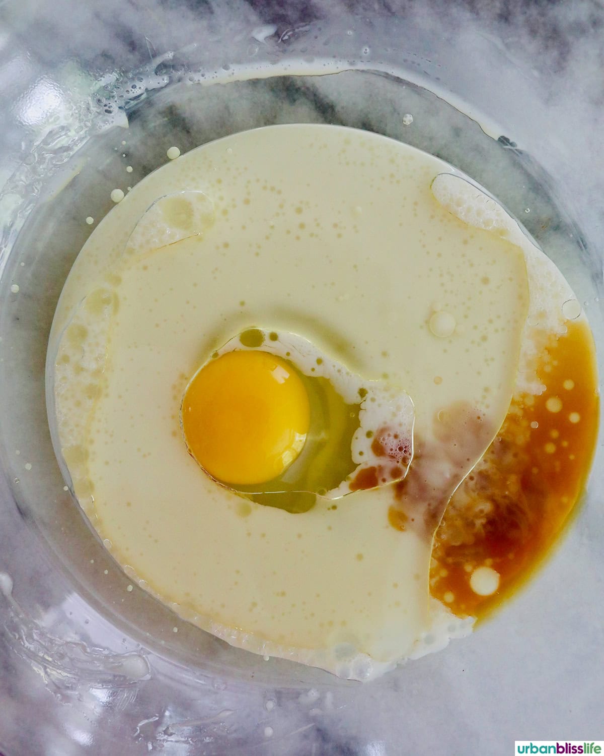 milk, eggs, vanilla extract in a bowl.