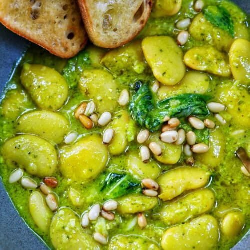 bowl of pesto beans with side of crostini.