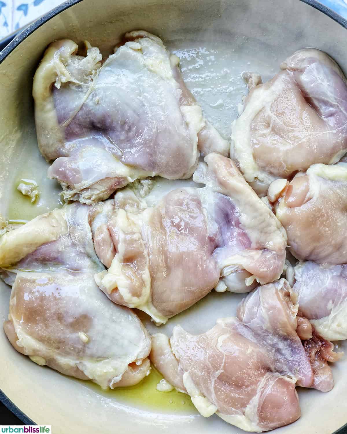 chicken thighs cooking in a pan.