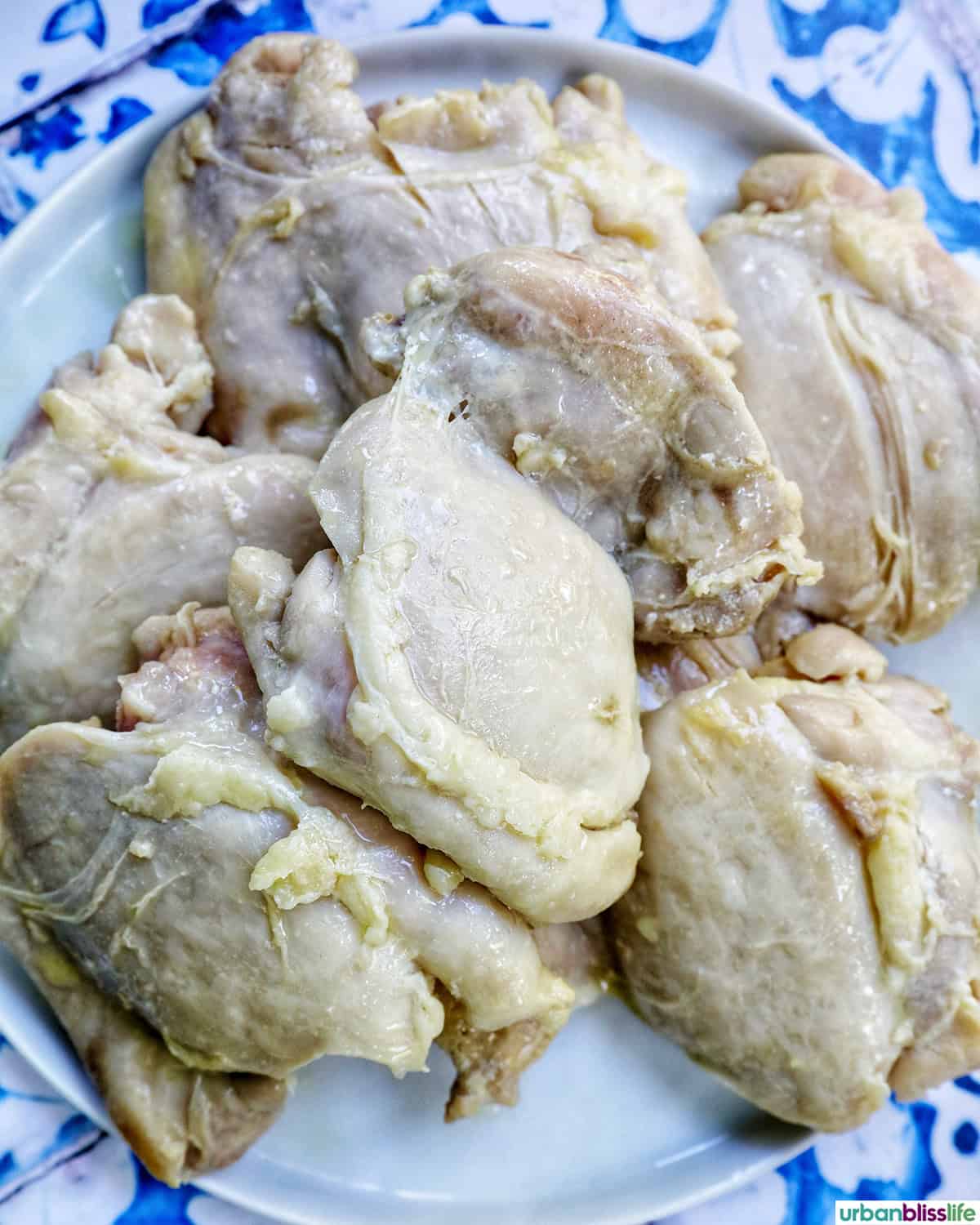 chicken thighs cooking in a pan.