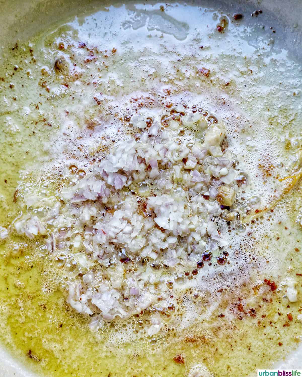 shallots and garlic sauteing in a pan.