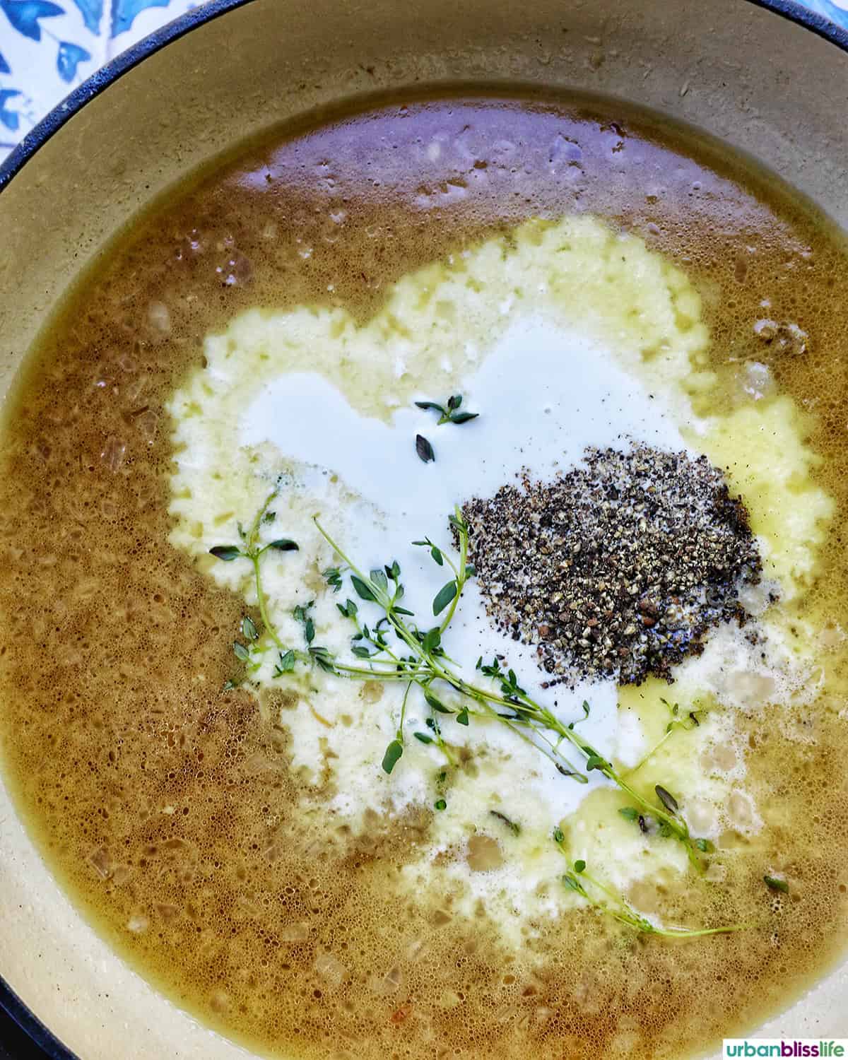 chicken broth, heavy cream, and herbs and spices in a pan.