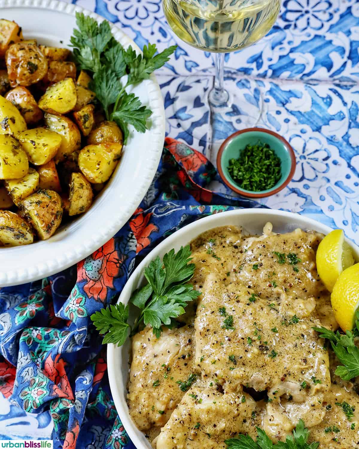 bowl of herby potatoes next to a bowl of chicken au Poivre.