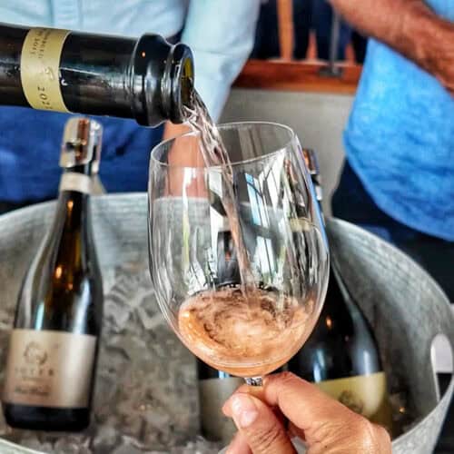 hand holding a glass of sparkling rosé wine being poured into it at Method Oregon.
