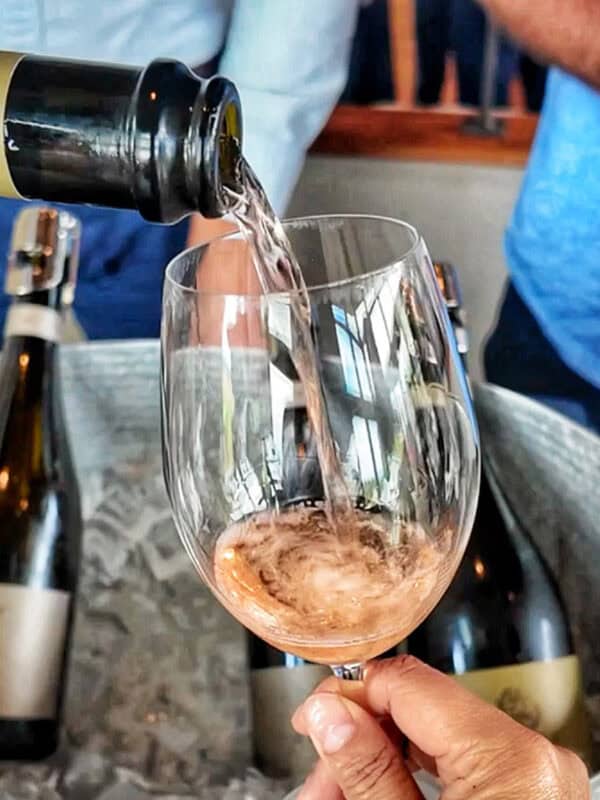 hand holding a glass of sparkling rosé wine being poured into it at Method Oregon.