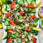 Thai beef noodle salad with tomatoes, cucumbers, and limes.