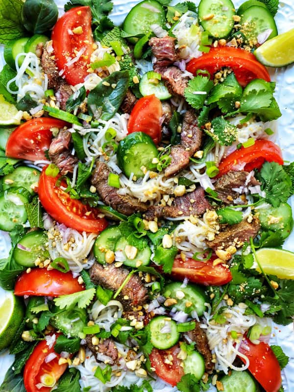Thai beef noodle salad with tomatoes, cucumbers, and limes.