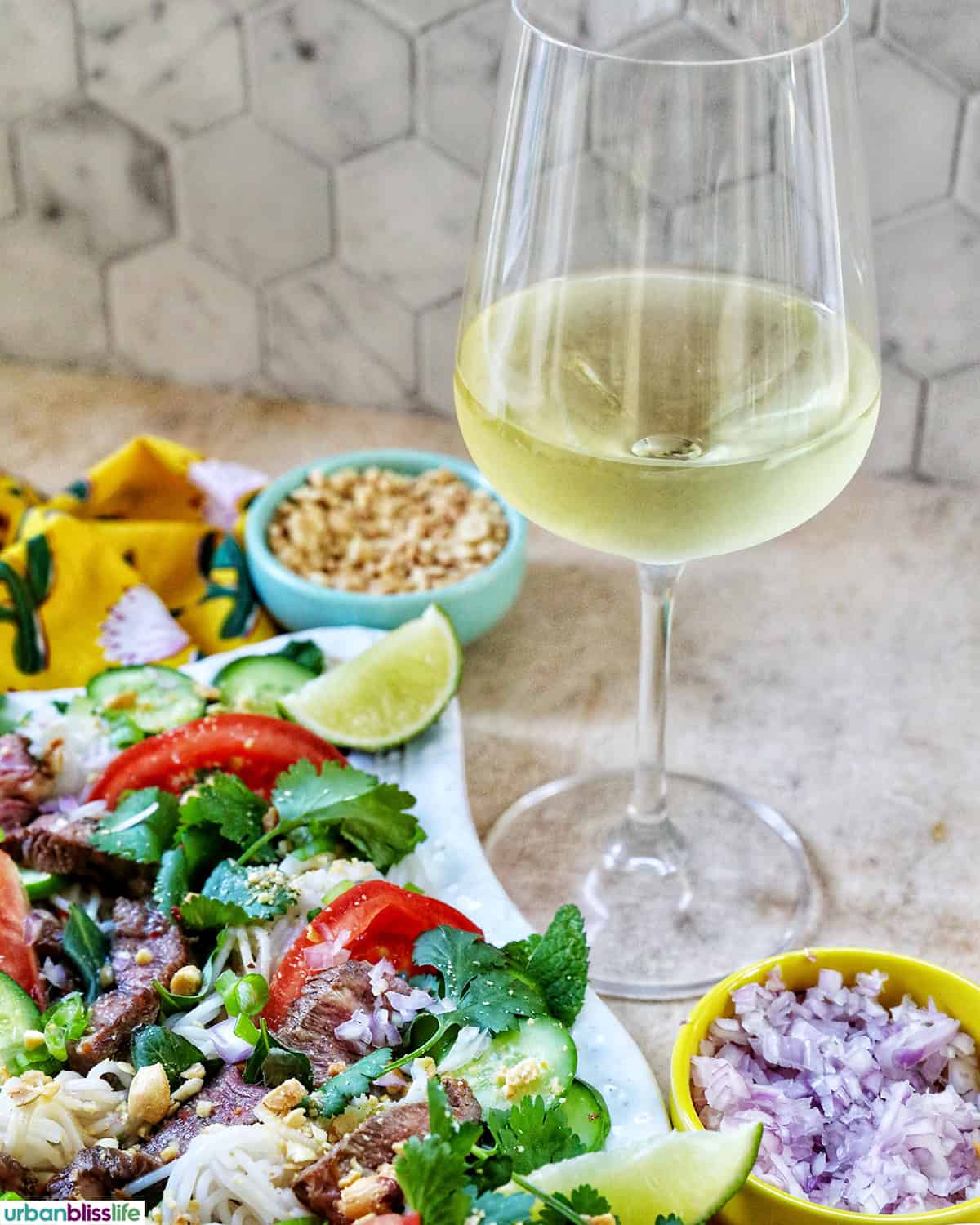 glass of white wine with Thai beef noodle salad.