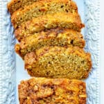 sliced apple cinnamon loaf cake on a white platter.