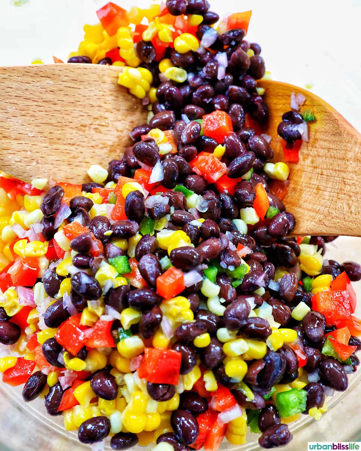 black bean corn dip in a bowl with wooden spoons.