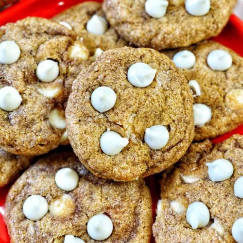 stack of pumpkin white chocolate chip cookies on an orange plate.