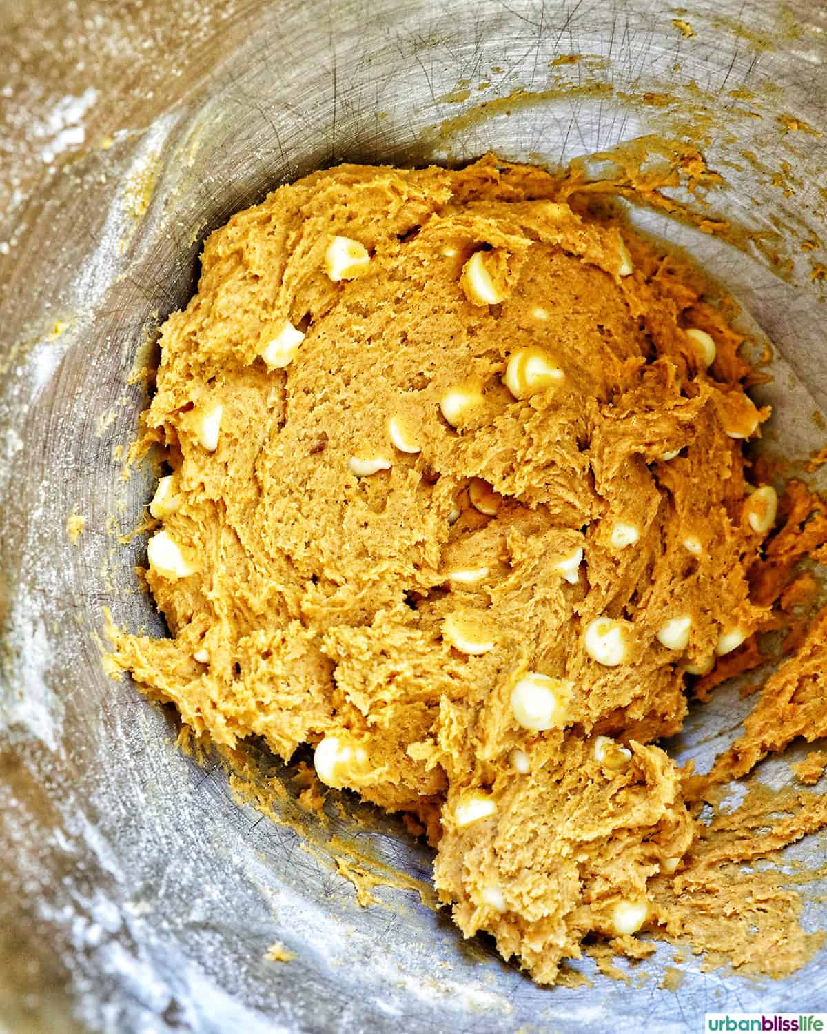 white chocolate chip cookie batter in a bowl with white chocolate chips.
