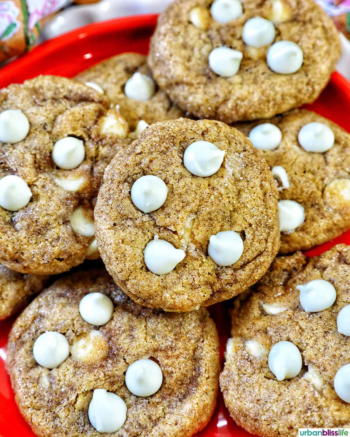 stack of pumpkin white chocolate chip cookies on an orange plate.