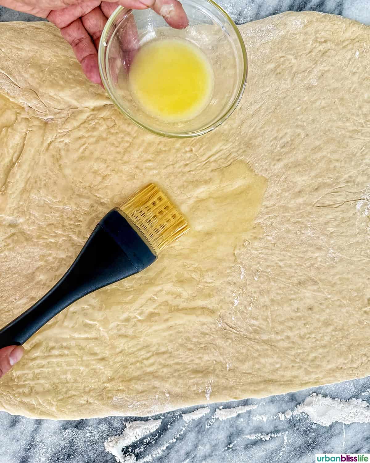 pastry brush brushing butter onto dough.
