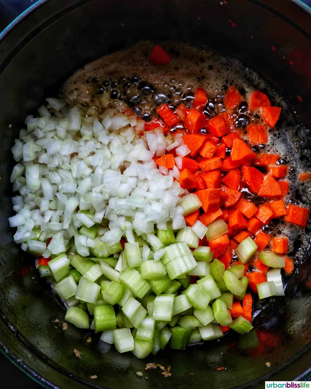 carrots, celery, garlic, onions cooking in a pot.
