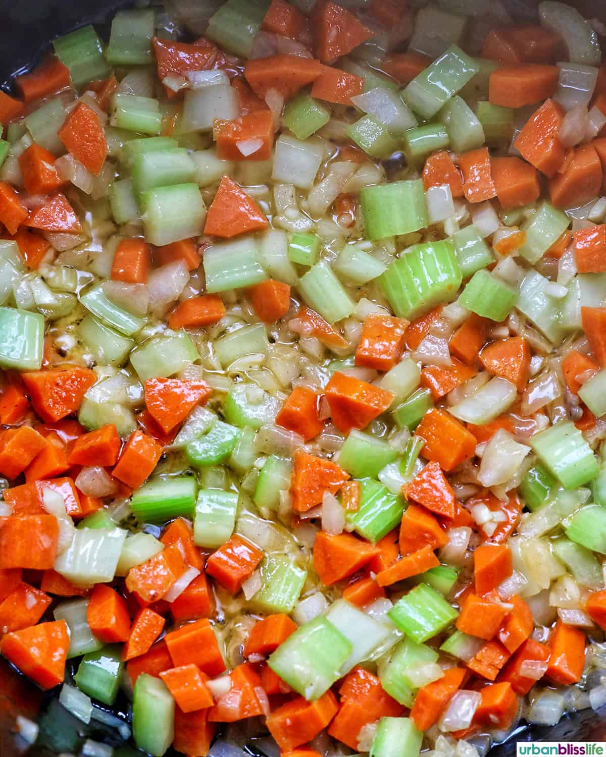 carrots, celery, garlic, onions cooking in a pot.